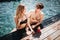 Young hot couple resting at swimpool. Sexy amazing man and woman in swimwear look at each other. Standing in swimpool
