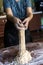 Young house wife preparing the homemade pasta at kitchen. Woman cutting long dough stripe for cooking pasta