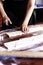 Young house wife preparing the homemade pasta at kitchen. Woman cutting long dough stripe for cooking pasta