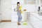 Young housekeeper cleaning floors with a broom