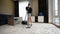 Young Housekeeper Hotel Maid Cleaning Carpet With Vacuum Cleaner In Hotel Room