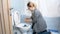 Young housewife with clothespin closing nose cleaning toilet at home