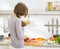 Young housewife cutting vegetables on salad