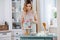 Young housewife decorating cake in her kitchen at home