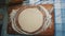 A young housewife kneads yeast dough on a wooden board.