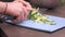 Young housewife slices cucumbers on plastic board