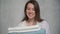 A young housewife woman holds a stack of fresh washed clean linen in her hands.