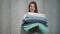 A young housewife woman holds a stack of fresh washed clean linen in her hands.