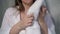 A young housewife woman takes a stack of fresh washed clean linen in her hands.