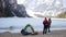 Young hugging couple standing on the coast of frozen lake and enjoying the view of mountains