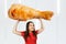 Young hunger pretty funny girl holds huge and large chicken big leg and laugh