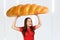 Young hunger pretty funny woman holds huge and large loaf. Girl walks with big heavy bun