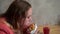 A young hungry girl eating a hamburger. Sitting at a table in a cafe