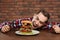 Young hungry man with cutlery eating huge burger