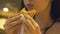 Young hungry woman with appetite eating tasty burger at fast food restaurant