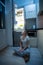 Young hungry woman sitting on kitchen floor at night and looking on the fridge