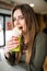 Young hungry woman sitting in a restaurant eating an doner hand hold- hunger, food, meal concept