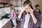 A young husband, a man, calls on the phone in the kitchen and is upset and indignant at the news against the background