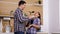 Young husband and wife fighting with kitchen tools and having fun