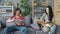 Young husband and wife reading books at home and stroking corgi puppy