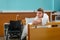 Young ill patient leaning on the hospital bedstead covered with