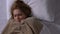 Young ill woman shivering with cold, covering blanket in bed, flu symptoms