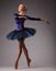 Young and incredibly beautiful ballerina in blue outfit is posing and dancing in studio. classical