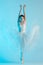 Young and incredibly beautiful ballerina is dancing in a blue studio