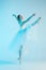 Young and incredibly beautiful ballerina is dancing in a blue studio