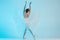 Young and incredibly beautiful ballerina is dancing in a blue studio