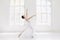 Young and incredibly beautiful ballerina is posing and dancing in a white studio