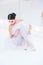 Young and incredibly beautiful ballerina is posing and dancing in a white studio full of light.