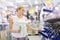 Young independent woman buying tools for house decoration in paint supplies shop.