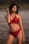 Young India girl in red bikini enjoying her vacation on beach and relaxing on beach