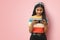 Young Indian Asian teenage girl smiling and playing online games on mobile phone or watching series isolated with mockup copy