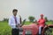 Young indian bank officer using laptop at agriculture field