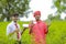 Young indian banker and farmer showing smartphone and card at green field