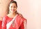 A young indian bengali assamese married lady dressed in red and white saree and smiling
