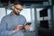 Young indian businessman using tablet device in modern corporate office.