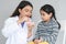 Young Indian dentist holding a jaw model and toothbrush, demonstrating right way to clean teeth and gums by brushing properly to