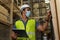 Young Indian factory warehouse worker wearing a protective face mask while working in logistic industry. 30s man