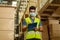 Young Indian factory warehouse worker wearing a protective face mask while working in logistic industry. 30s man