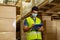 Young Indian factory warehouse worker wearing a protective face mask while working in logistic industry. 30s man