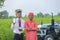 Young indian farmer and agronomist showing smartphone screen at field