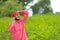 Young indian farmer talking on mobile phone at green pigeon field