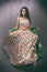 Young Indian female wearing ethnic green floral summer dress with jewelry and makeup