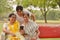 A young Indian girl with mother and mother in law - senior graceful women gossiping and smiling at the mobile phone screen while