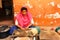 Young indian girl working with aroma sandalwood incense at traditional house with colorful walls