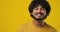 Young indian man satisfied happy guy standing over yellow background