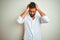 Young indian man wearing elegant shirt standing over isolated white background suffering from headache desperate and stressed